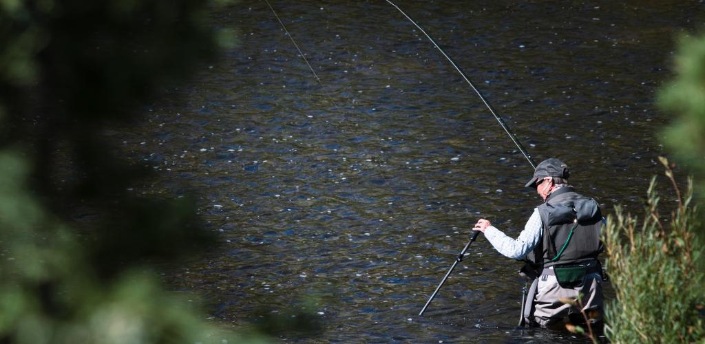 Mann fisker i elva